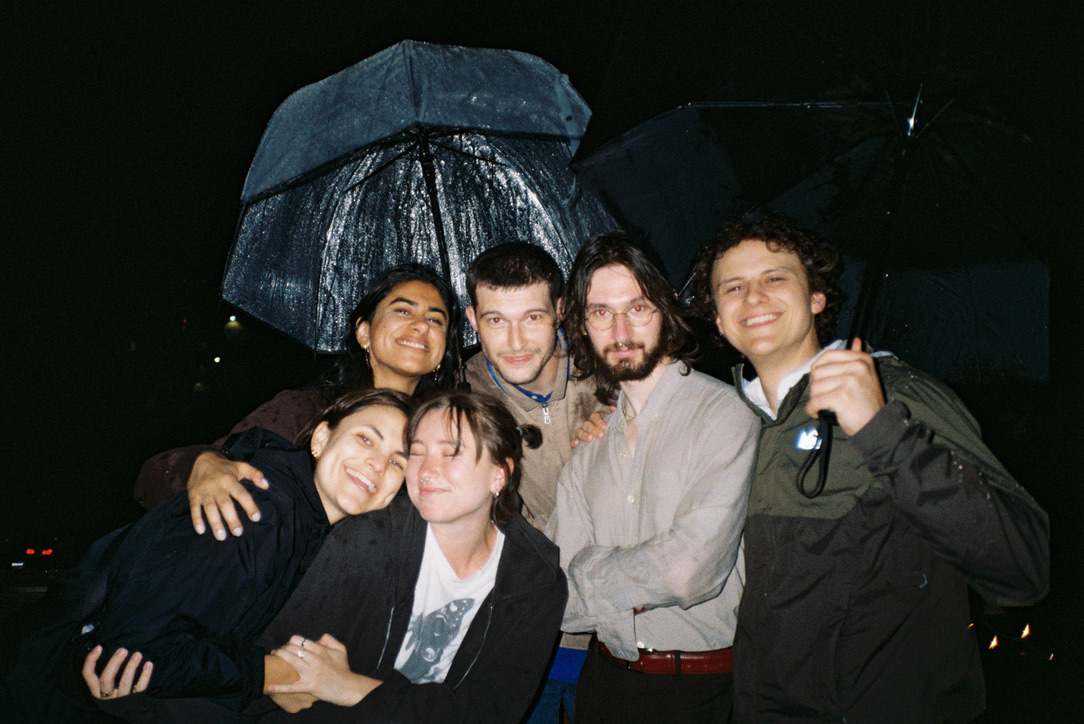 Friends gathered under umbrellas at night